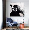 a room with a blue chair and a picture of a monkey with headphones on