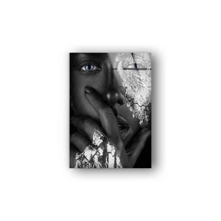 Dramatic glass wall art featuring a textured metallic face with glowing blue eye details.