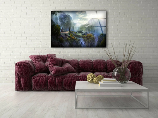 Foreground shows a modern living room with a Hidden Valley Village Waterfalls Mountain Paradise glass wall art decor displayed above a plush sofa.