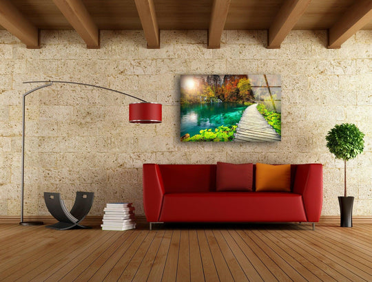 Textured stone blocks in the background complement this nature glass art painting of a serene wooden path beside an emerald lake.
