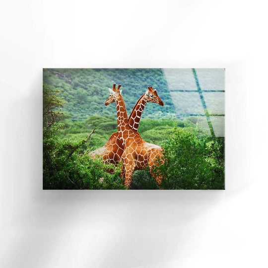 A pair of giraffes stands back-to-back amidst lush green foliage in this detailed glass art painting.