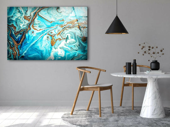 A neutral gray wall serves as a backdrop for abstract hanging wall art featuring turquoise and gold marble patterns.