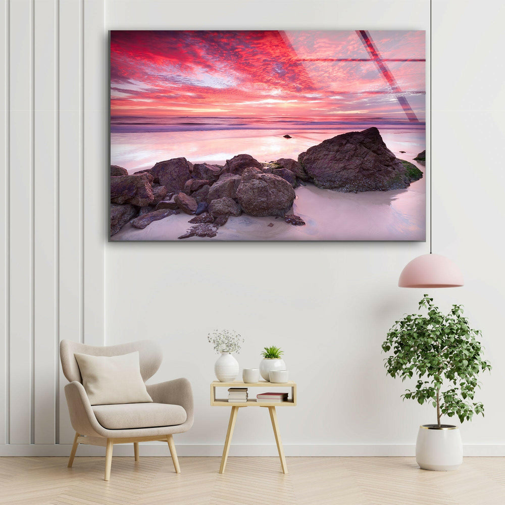 Stunning coastal scene featuring a pink and purple sunset with ocean waves.
