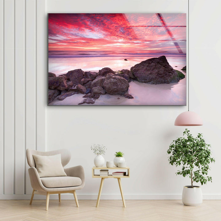 Stunning coastal scene featuring a pink and purple sunset with ocean waves.
