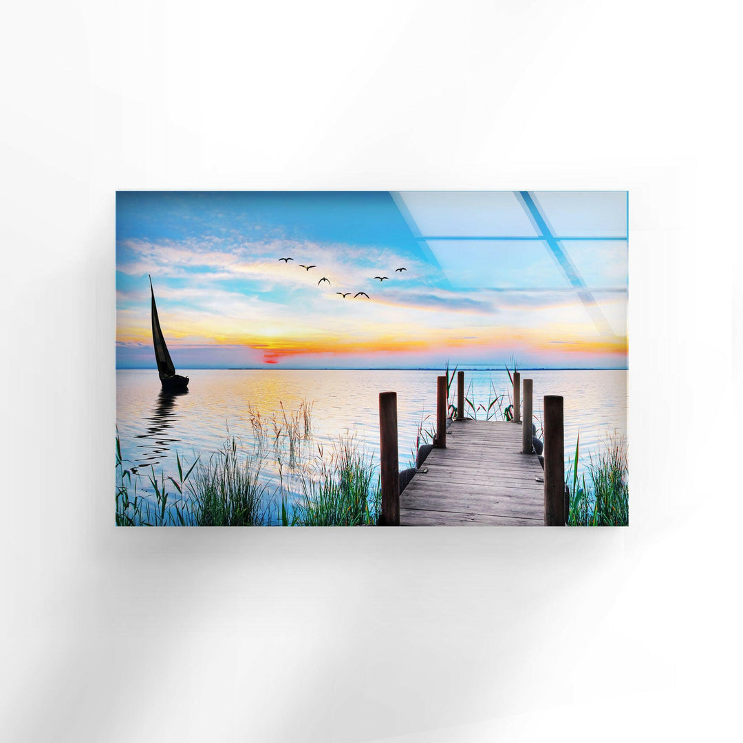 Nature paintings for sale depicting a tranquil wooden pier leading into a stunning sunset on a calm lake.
