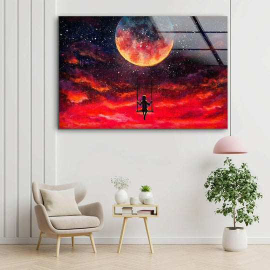 Dark, shadowy cosmic clouds frame a solitary figure on a swing, with a vast, fiery full moon illuminating the expanse of glass wall art decor.