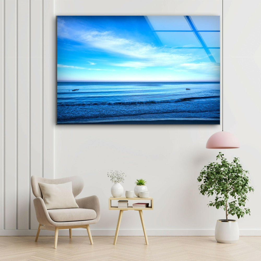 A tranquil sea view with a serene blue sky reflecting on the water.
