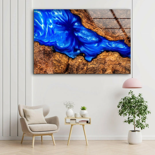 Abstract glass wall art captures organic forms in swirling sapphire blue epoxy with natural wood textures.