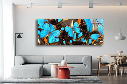 Blue Butterflies glass wall art showcases vibrant blue and brown butterfly wings and is a stunning piece of nature inspired modern wall decor perfect for a living room above a sofa