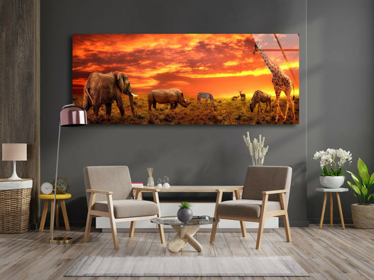 The panoramic glass wall art shows elephants giraffe zebra and rhino animals at savanna with vivid sunset colors and is safari themed wall decor
