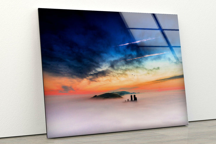 Mysterious castle remains rising through thick mist at sunset.
