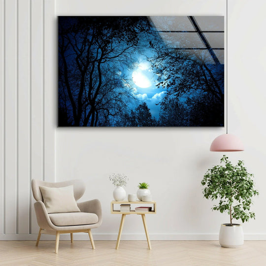Mysterious night forest glass wall art shows a glowing moon and dark trees and is landscape art and forest themed and casting a mystical glow on a wall