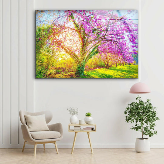 Radiant cherry blossom glass wall art decor shines as the focal point, showcasing a sunlit tree in full bloom with vibrant pink blossoms against a lush landscape.