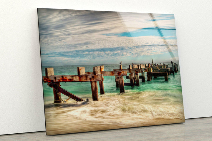 Ocean Waves and Wooden Pier Remnants – A Captivating Glass Print
