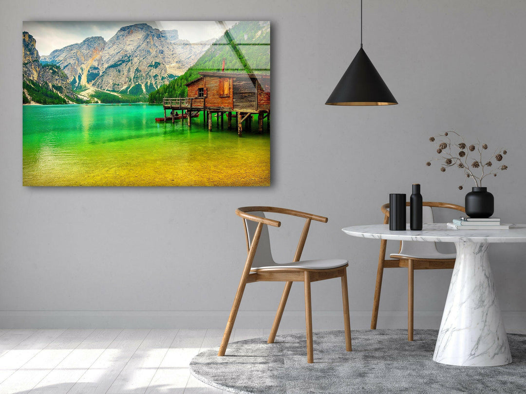 A stunning landscape photo for sale showcasing a cozy lakeside cabin amid mountains.
