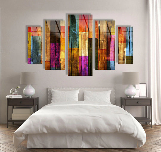 Soft neutral wall paint provides a calming backdrop for the colorful wooden pattern glass wall art, showcasing the best glass art in a bedroom setting.