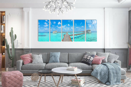 Negative space around the five-panel Bungalows Maldives Island Landscape art from glass emphasizes the ocean's bright turquoise against the minimalist decor.