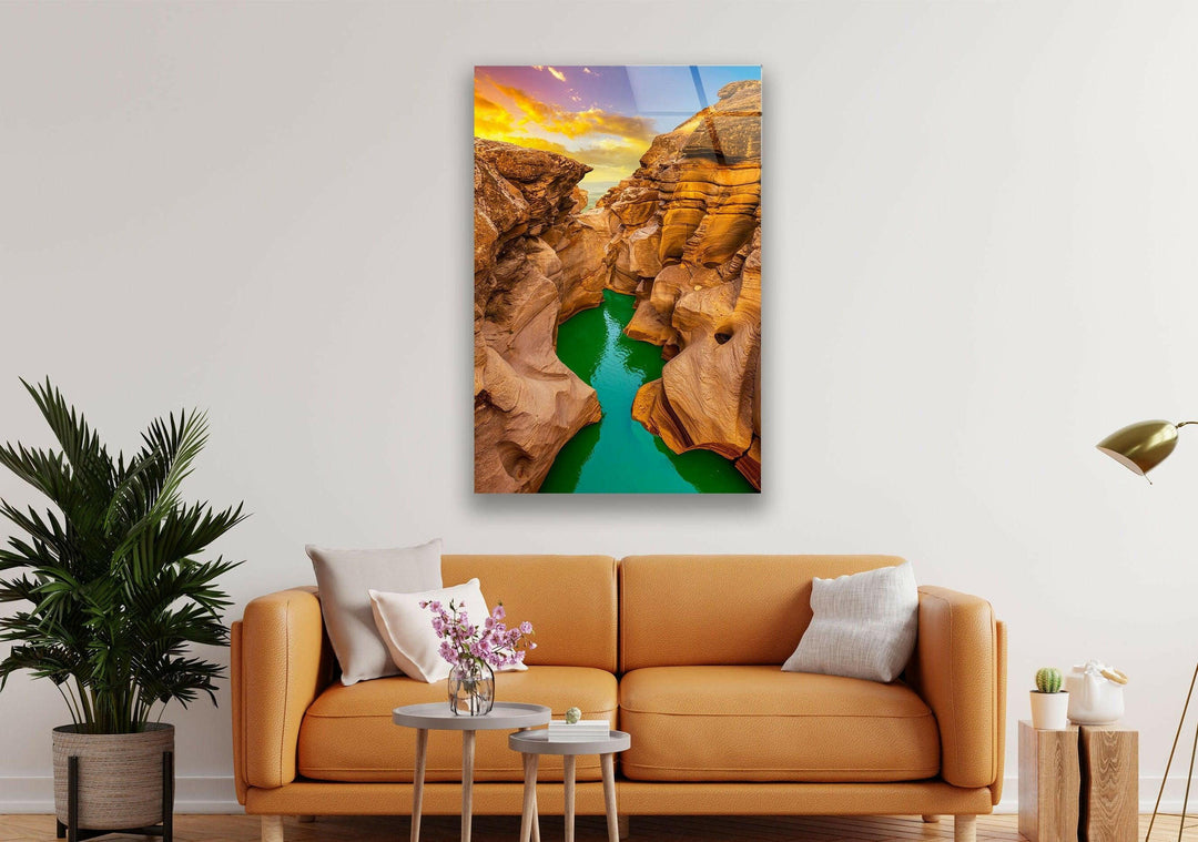 Stunning canyon sunset reflecting in turquoise waters, creating a mesmerizing natural scene.
