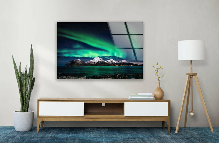 Serene Arctic scenery featuring glowing green auroras and snowy mountains.
