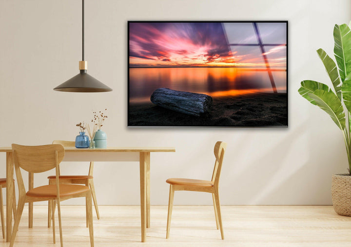 A mesmerizing seascape featuring a fiery sunset and glassy water reflections.
