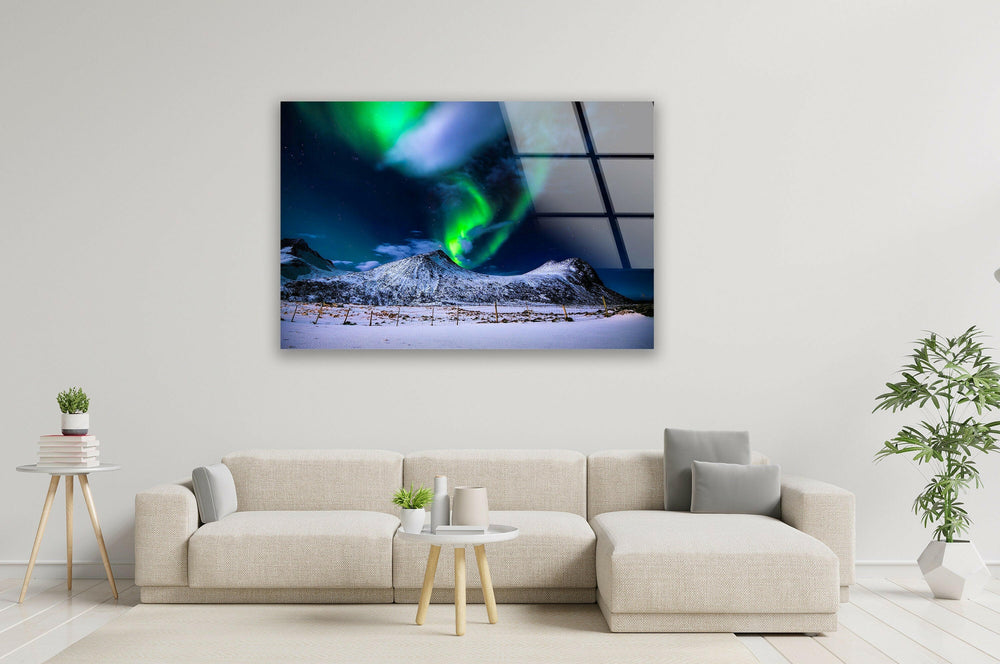 Breathtaking aurora borealis illuminating a winter landscape on glass wall art.
