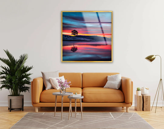 Warm hues of reds and oranges contrast with cool blues in this landscape glass wall art, a piece of unique modern wall decor.