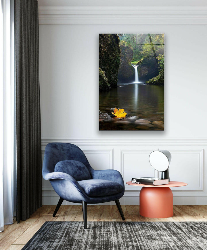 Soothing waterfall with a golden autumn leaf resting on the water, perfect for relaxation.

