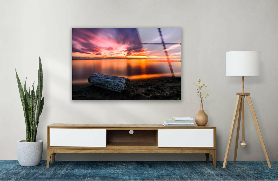 Dramatic clouds streaked with pink and orange above a tranquil ocean.
