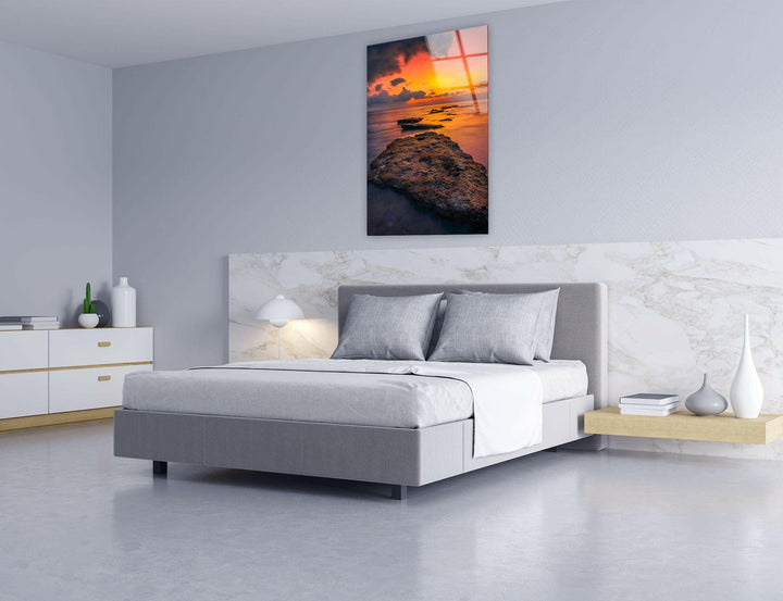 Tranquil seascape with waves gently meeting a rocky shore at dusk.
