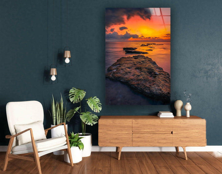 Luxury glass wall art featuring a dramatic coastal sunset with deep golden tones.
