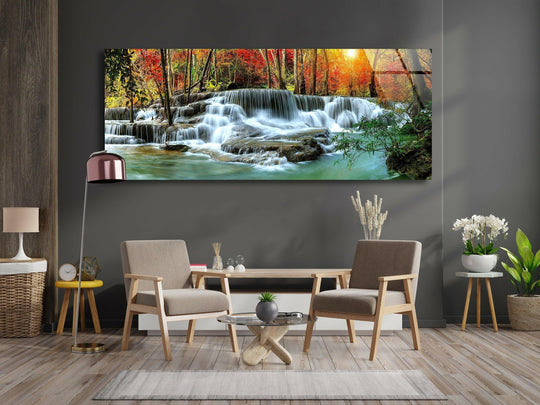 Nature Landscape glass wall art showcases a serene waterfall and autumn trees and is a panoramic statement piece with vibrant colors and a glossy finish above a sofa