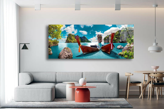 Phuket Island glass wall art showcases a scenic tropical landscape and vibrant turquoise waters with traditional boats above a gray sofa