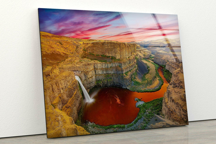 A mesmerizing canyon scene with a deep red pool and a flowing waterfall.
