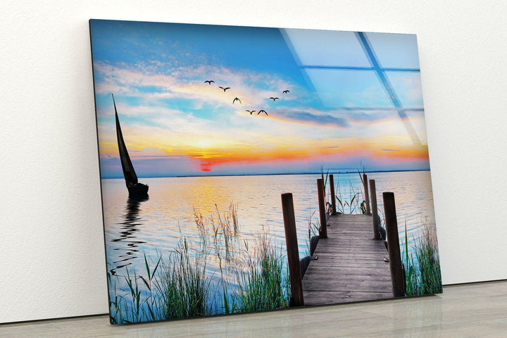 Nature art prints featuring a sailboat and a wooden dock at sunset, perfect for any coastal-themed room.
