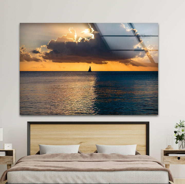 Perfect sunset tranquility over the ocean, with a sailboat and golden horizon.
