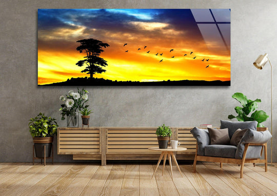 Panoramic glass wall art showcasing sunset nature silhouette in vibrant colors and it is a peaceful scenic decor for landscape wall art