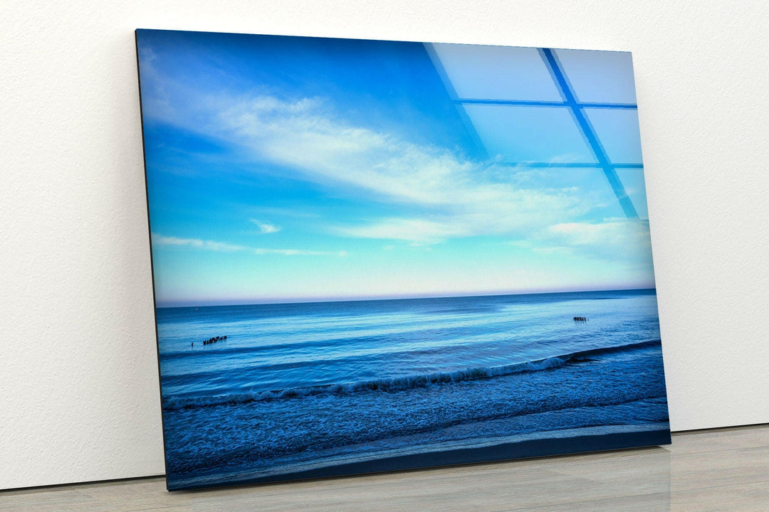 A relaxing beachside view with endless blue waters and a clear sky.
