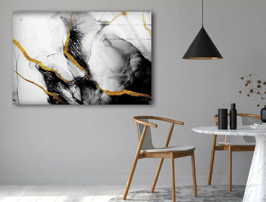 Modern abstract glass printing features swirling black and white marble textures with striking gold accents on a light gray wall background.
