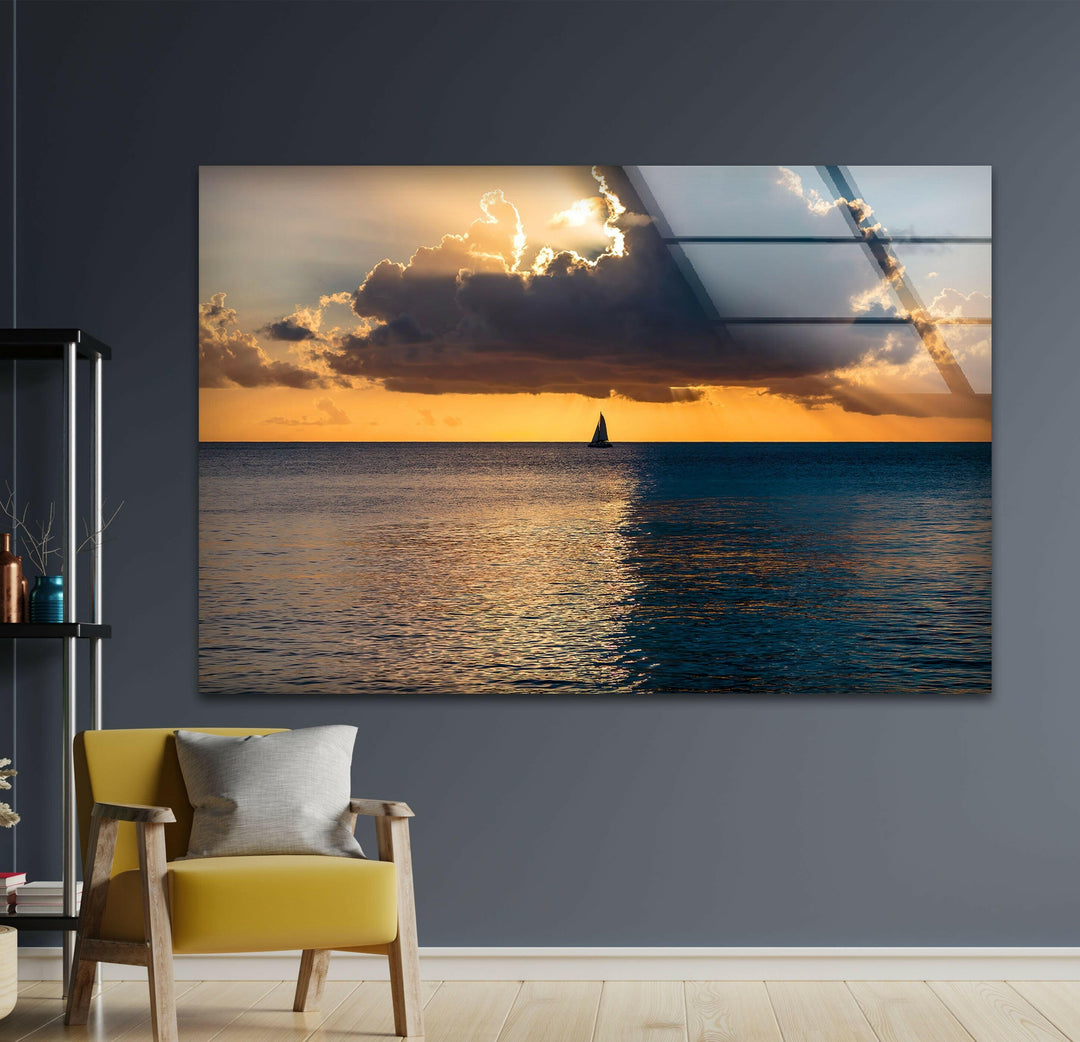Majestic golden sunset reflecting on the calm waters, with a sailboat gliding by.
