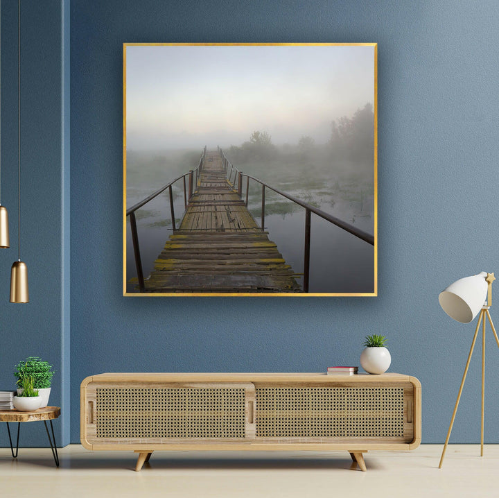 Mysterious wooden pathway disappearing into dense morning fog over a river.
