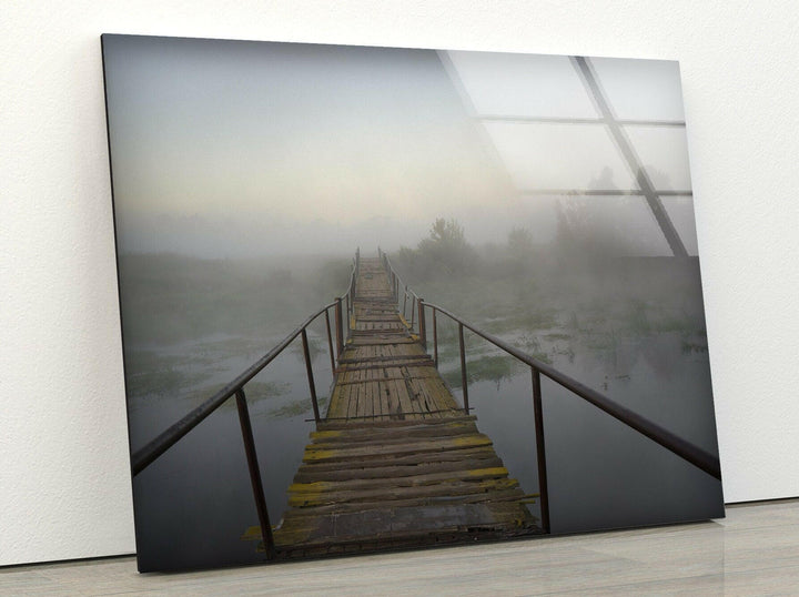 Atmospheric foggy landscape with an old wooden bridge leading into the unknown.
