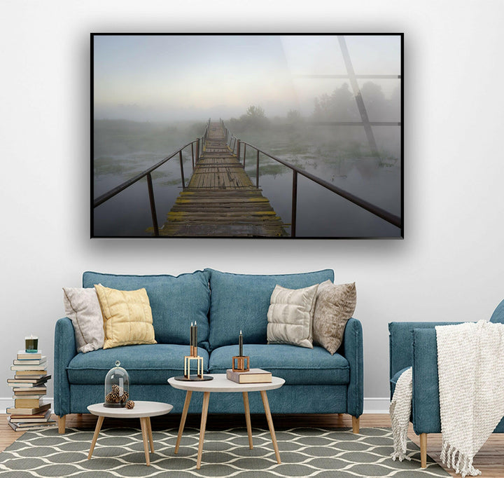 Peaceful foggy morning scene featuring a weathered bridge over tranquil water.
