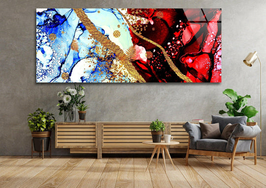 Red and blue ink abstract glass wall art features gold accents and a panoramic design above a wooden sideboard in a living room