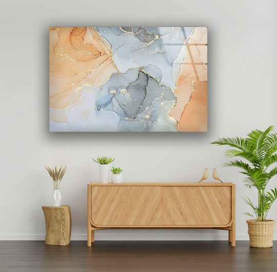 Warm peach and cool gray swirls with gold contrast in this abstract glass wall art.