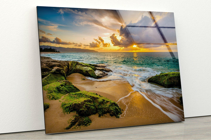 Rocky coastline at sunset, illuminated by golden sunlight reflecting off the water.
