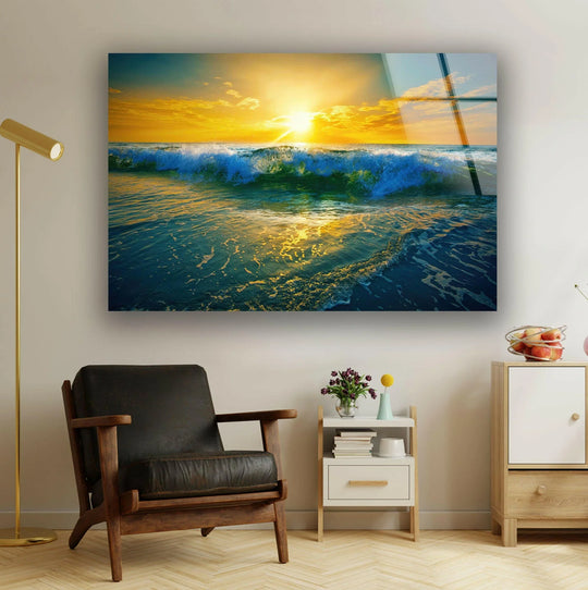 Sunrise Ocean Waves glass wall art shows crashing ocean wave and yellow sunrise and it is ocean themed wall decor and coastal landscape wall art