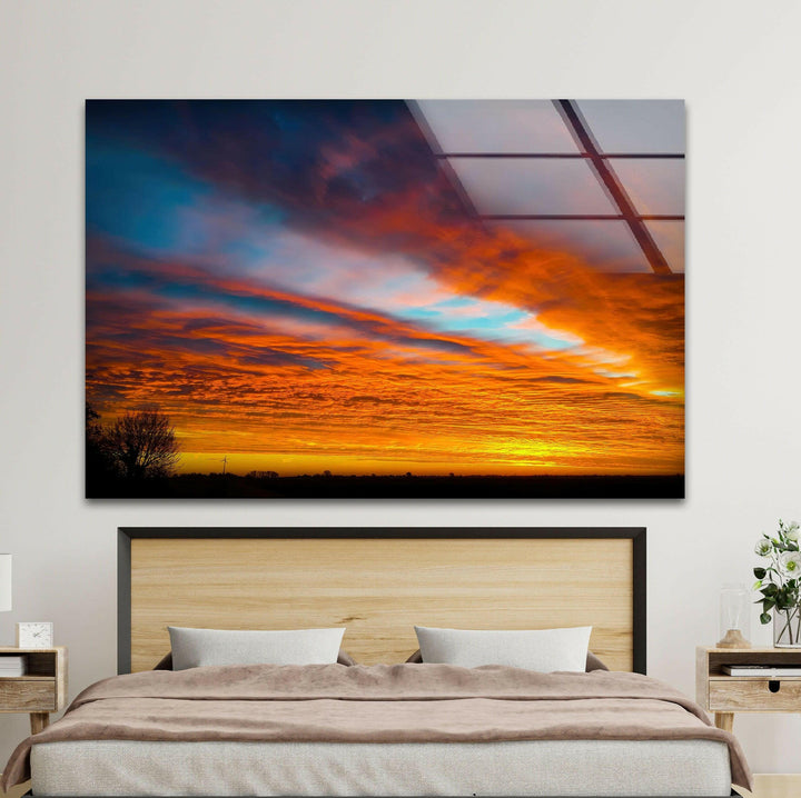 Stunning orange and red clouds swirl over the horizon in this fiery sunset art piece.

