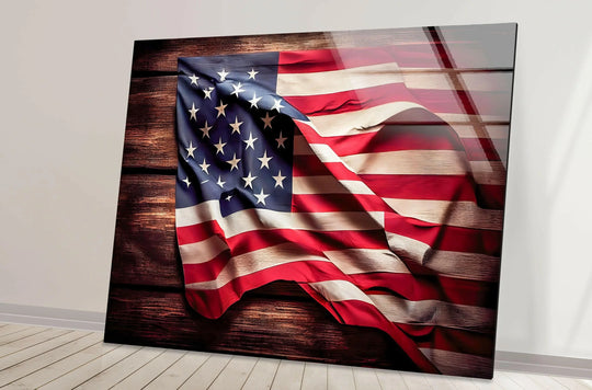 A horizontal rectangular US flag glass wall art features a wavy American flag on a dark wooden plank background, creating unique modern wall decor.