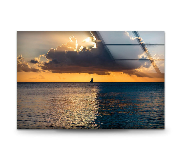 A perfect blend of sky and sea in a golden ocean sunset, featuring a peaceful sailboat.
