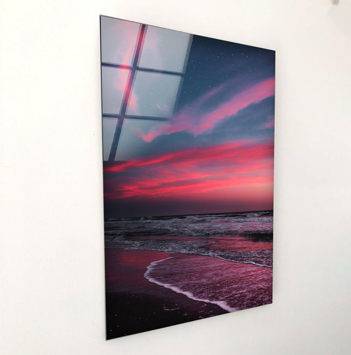 Stunning ocean shoreline at sunset with rich crimson and purple tones on glass.
